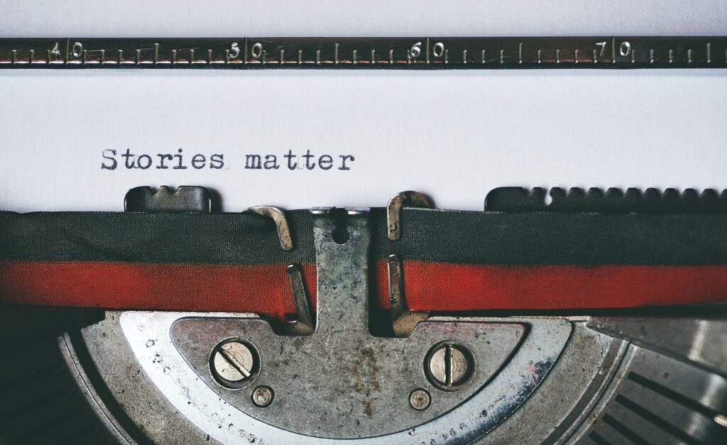 page in typewriter reading "Stories matter".